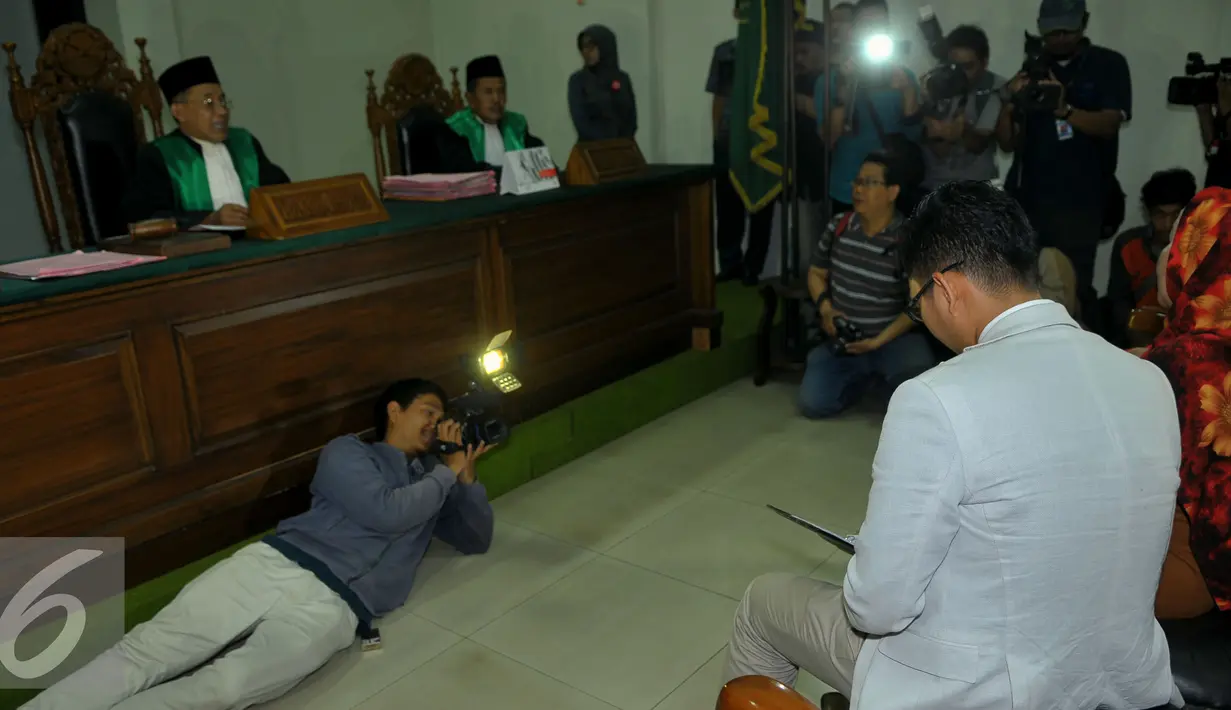 Seorang pewarta tampak mengambil gambar Muzdalifah saat mengikuti sidang perdana gugatan cerai kepada suaminya Nassar, Pengadilan Agama Tanggerang, Selasa (1/9/2015). Nazar tidak hadir karena ada pekerjaan di luar negeri. (Liputan6.com/Faisal R Syam)