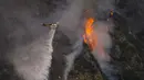 Sebuah helikopter menjatuhkan air ke Ranch Fire di Azusa, California, Amerika Serikat, 13 Agustus 2020. Gelombang panas menyulitkan petugas pemadam kebakaran yang sedang memerangi kebakaran semak dan kebakaran hutan di California Selatan. (AP Photo/Marcio Jose Sanchez)
