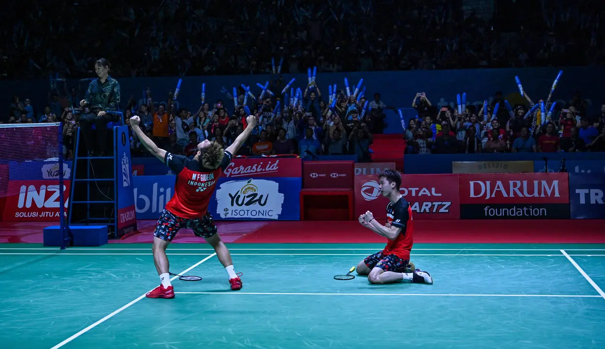 Ganda putra Kevin Sanjaya/Marcus Fernaldi Gideon berselebrasi usai mengalahkan Mohammad Ahsan/Hendra Setiawan pada pertandingan final Indonesia Open 2019 di Istora Senayan, Minggu (21/7/2019). Kevin/Marcus menang 21-19, 21-16. (AFP Photo/Adek Berry)