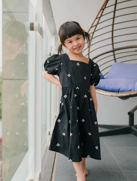 Berpose manis sambil menaruh satu tangannya di pinggang, Natusha terlihat mengenakan midi dress hitam dengan motif bunga-bunga yang kecil. Ia juga terlihat menguncir dua rambutnya. Foto: Instagram.