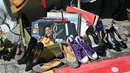 Catatan bekas, sepatu, dan barang-barang lainnya terlihat di sebuah kios di Classic Car Boot Sale, London, Inggris, 7 Agustus 2021. Classic Car Boot Sale berlangsung selama dua hari. (JUSTIN TALLIS/AFP)