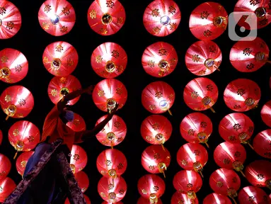 Seorang pekerja memasang lampion pemberian umat di Klenteng Boen San Bio, Tangerang, Kamis (28/1/2021). Sebanyak 800  lampion dipasang untuk mempercantik Klenteng jelang perayaan Tahun Baru Imlek. (Liputan6.com/Angga Yuniar)