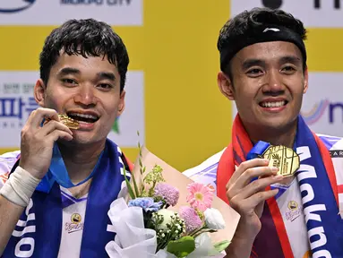 Ganda putra Indonesia, Leo Rolly Carnando (kiri) dan Bagas Maulana merayakan kemenangan di podium setelah pertandingan final bulu tangkis ganda putra Korea Open di Mokpo Indoor Stadium, Minggu 1 September 2024. (ANTHONY WALLACE/AFP)