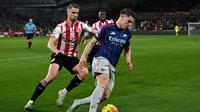 Striker Arsenal, Viktor Gyokeres, mengontrol bola saat dibayangi bek Brentford, Kristoffer Ajer, saat kedua tim berhadapan dalam lanjutan Premier League 2025/2026 di Gtech Community Stadium, London, Jumat (13/2/2026) dini hari WIB. (Glyn KIRK / AFP)