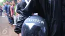 Seorang warga memegang helm Uber usai melakukan pendaftaran menjadi pengemudi Uber di Jakarta, Selasa (24/5). Antusias warga untuk mendaftat ojek Online masih sangat besar bila dilihat dari jumlah pendaftar. (Liputan6.com/Angga Yuniar)