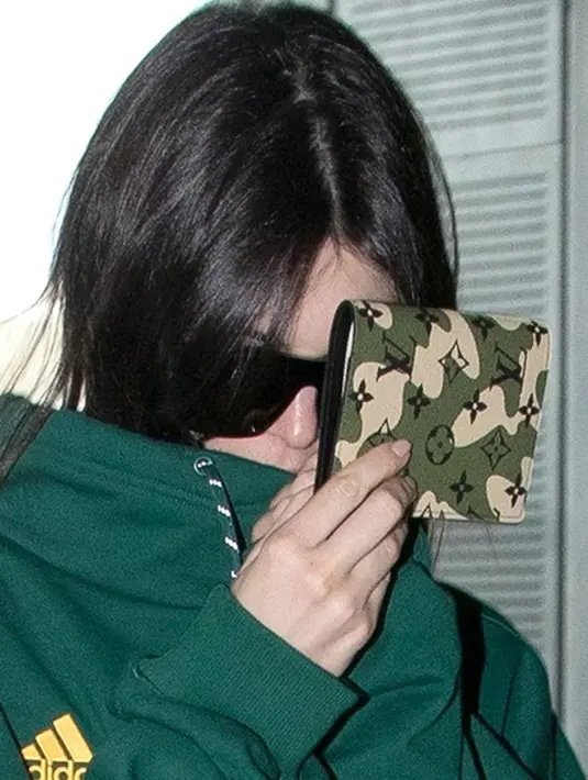 Kini berada di Paris, Kendal Jenner dengan sengaja menutupi bibirnya. (HollywoodLife)