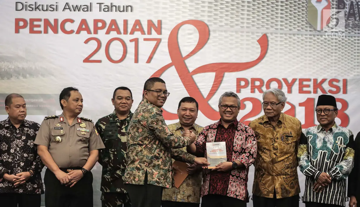 Anggota Bawaslu RI Fritz Edward Siregar memberikan buku laporan kerja Bawaslu kepada Ketua KPU Arief Budiman di Jakarta, Kamis (25/1). Dari 66 permohonan, 24 dikabulkan, 37 ditolak, tiga dinyatakan gugur, dan dua kedaluwarsa. (Liputan6.com/Faizal Fanani)