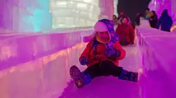 Seorang anak bermain di bangunan yang terbuat dari es saat Festival Es dan Salju di Harbin, Tiongkok, Rabu (4/1). Event tahunan tersebut merupakan salah salah satu festival yang cukup dinanti oleh wisatawan.( AFP PHOTO / Nicolas ASFOURI)