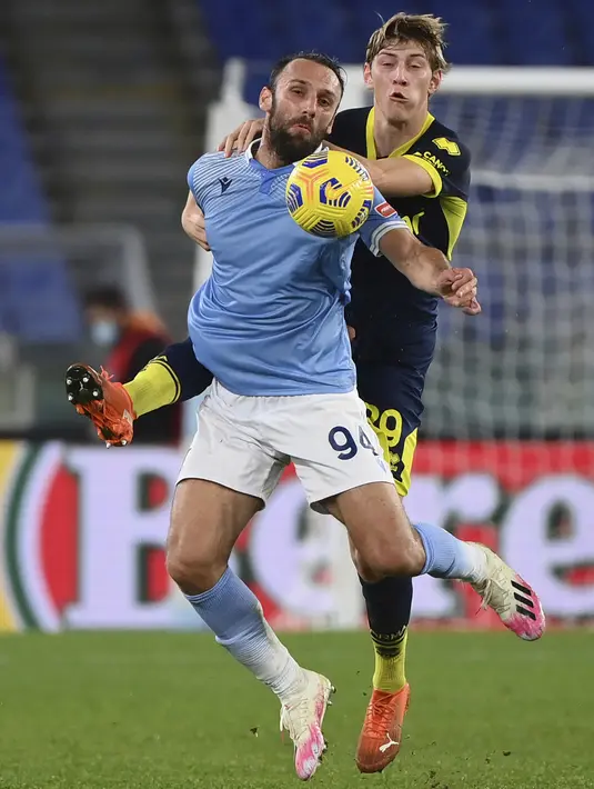 Bek Parma, Daan Dierckx berusaha merebut bola dari penyerang Lazio, Vedat Muriqi pada pertandingan babak 16 besar Coppa Italia di Stadion Olimpiade Roma di Roma, Italia, Jumat (22/1/2021). Dengan kemenangan ini Lazio akan menghadapi Atalanta. (Alfredo Falcone/LaPresse via AP)