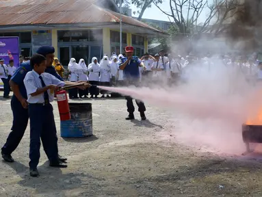 Seorang siswa berlatih memadamkan api menggunakan alat pemadam di Banda Aceh, Senin (11/11/2019). Sebanyak 439 pelajar mendapat pembekalan cara pencegahan pemadaman api akibat kebakaran dari petugas Dinas Pemadam Kebakaran dan Penyelamatan Kota Banda Aceh. (CHAIDEER MAHYUDDIN/AFP)
