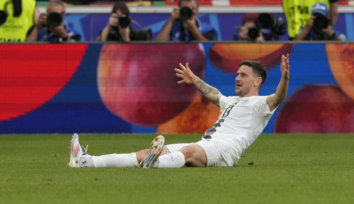 Selebrasi bek Timnas Slovenia, Erik Janza setelah mencetak gol penyeimbang 1-1 ke gawang Timnas Denmark pada laga Grup C Euro 2024 di MHPArena, Stuttgart, Jerman, Minggu (16/6/2024). (AP Photo/Antonio Calanni)