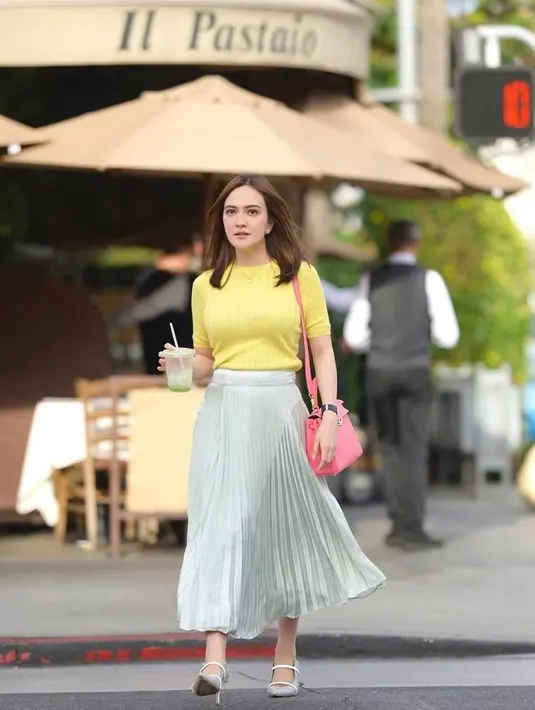 Gaya feminin Shandy Aulia dalam balutan top warna kuning dan pleated skirt warna silver. Cocok buat hangout maupun ke kantor (Instagram/shandyaulia).