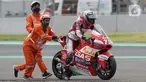 Marshal mendorong motor pembalap Albert Arenas yang keluar lintasan saat kualifikasi Moto2 di Pertamina Mandalika International Street Sirkuit, Lombok, NTB, Sabtu (19/3/2022). Marshal adalah petugas yang membantu di area lintasan saat terjadi insiden dalam balapan. (Liputan6.com/Helmi Fithriansyah)