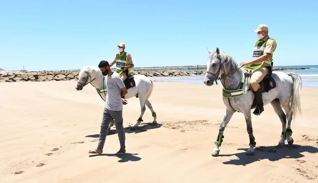 Sejumlah tentara berkuda yang berpatroli di sebuah pantai mengawal seorang pria agar meninggalkan lokasi tersebut di Sale, Maroko, Minggu (14/6/2020). Maroko pada 14 Juni 2020 mengumumkan 101 infeksi baru COVID-19, menambah jumlah kasus terkonfirmasi di negara tersebut menjadi 8.793. (Xinhua/Chadi)