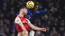 Striker Chelsea, Tammy Abraham, berebut bola dengan bek Arsenal, Shkodran Mustafi, pada laga Premier League pekan ke-24 di Stamford Bridge, London, Rabu (22/1). Arsenal tahan imbang Chelsea 2-2. (AFP/Daniel Leal-Olivas)