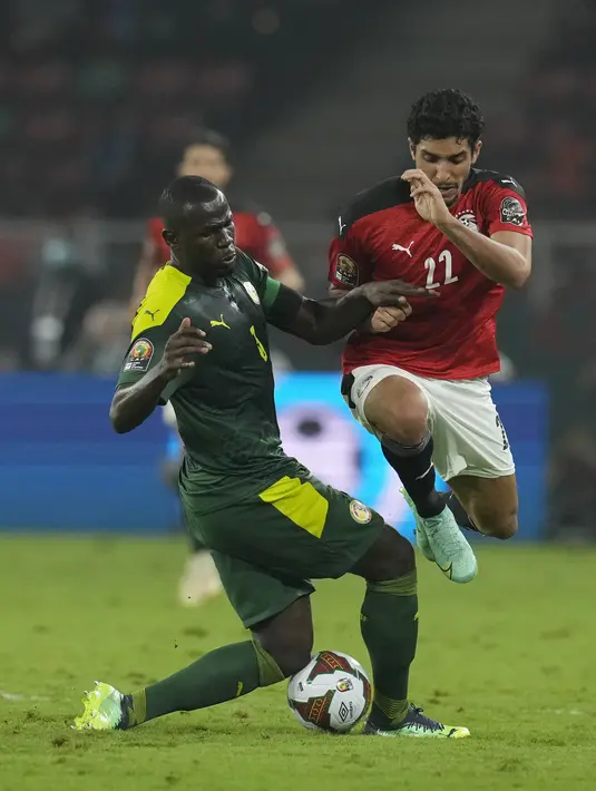 Gelandang Mesir Ramadan Sobhi berebut bola dengan bek Senegal Kalidou Koulibaly pada pertandingan final Piala Afrika 2021 di Paul Biya Stadium, Kamerun, Senin (7/2/2022) dini hari WIB. Sadio Mane membawa Senegal mengalahkan Mesir lewat adu penalti dengan skor 4-2. (AP Photo/Themba Hadebe)