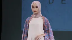 Seorang model berpose saat membawakan rancangan Ria Miranda yang bertema Dejavu di Hall Senayan City, Jakarta, Sabtu (10/12). Desainer Ria Miranda, memamerkan 5 koleksi dalam The Fourth Annual Trend Show 2017. (Liputan6.com/Herman Zakharia)