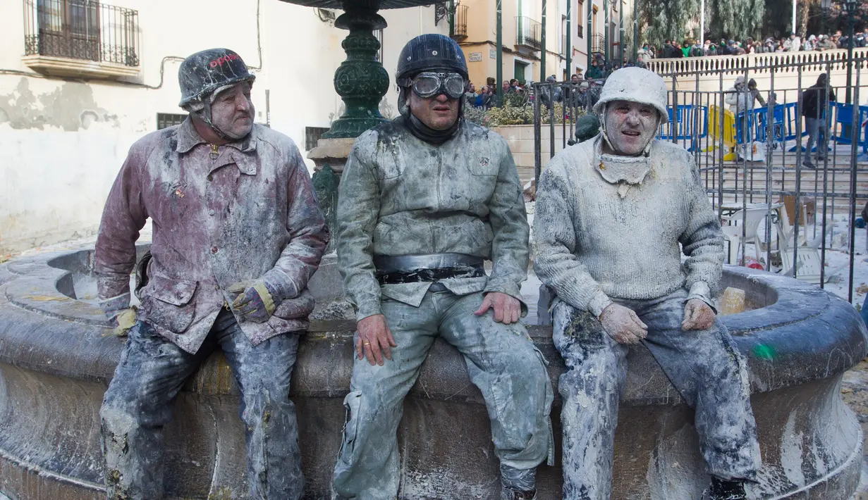 Peserta yang tubuhnya dipenuh tepung dan telur beristirahat saat festival tradisional Els Enfarinats di Ibi, Alicante, Spanyol (28/12). Festival tradisional berusia 200 tahun ini menjadi tradisi warga setempat. (AFP Photo/Jaime Reina)