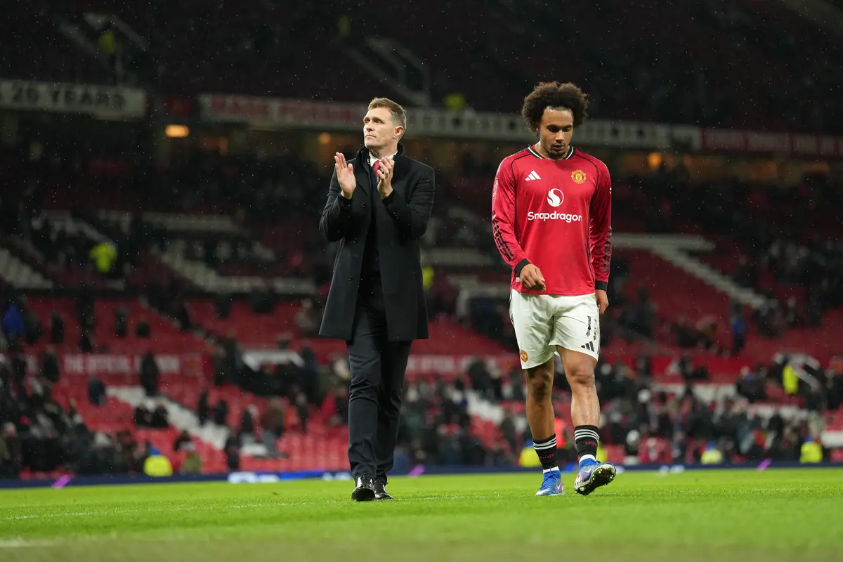 Manajer interim Manchester United Darren Fletcher berjalan meninggalkan lapangan bersama pemain Manchester United Joshua Zirkzee
