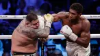 Petinju Anthony Joshua (kanan) melakukan pukulan ke wajah Andy Ruiz Jr (kiri) dalam pertandingan kejuaraan tinju kelas berat dunia di Diriyah Arena, Riyadh, Arab Saudi, Minggu (8/12/2019). Anthony Joshua menang angka mutlak atas Andy Ruiz Jr. (AP Photo/Hassan Ammar)