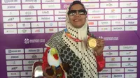 Pecatur Indonesia peraih dua medali emas di Asian Para Games 2018, Debi Ariesta, berpose dengan medalinya di GOR Cempaka Putih, Jakarta, Rabu (10/10/2018). (Bola.com/Benediktus Gerendo Pradigdo)