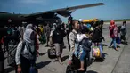 Seorang wanita membawa anaknya ketika mereka tiba di Surabaya, Kamis (4/10). Banyak anak-anak yang terpisah dari keluarganya setelah bencana gempa-tsunami melanda Palu dan Donggala pada 28 September. (AFP Photo/Juni Kriswanto)