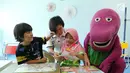 Perawat dan karakter Boneka Barney membimbing anak-anak bermain puzzle jelang peringati Hari Anak Nasional yang jatuh pada 23 Juli 2017 di RS Siloam Asri, Jakarta, Sabtu (22/07). (Liputan6.com/Fery Pradolo)