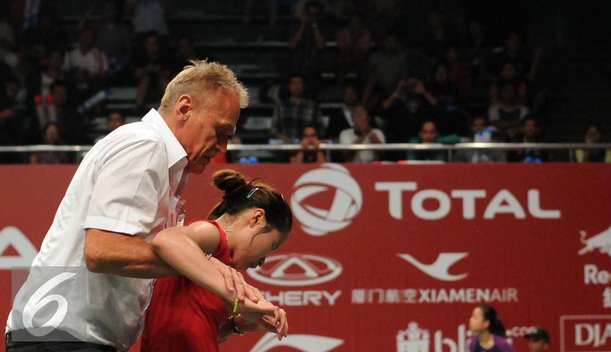 Tim medis membopong pebulutangkis Thailand, Ratchanok Intanon saat berlaga melawan Lindaweni Fanetri (Indonesia) di Total BWF Championships 2015 di Jakarta, Kamis (13/8/2015). Laga Intanon terhenti akibat cedera. (Liputan6.com/Helmi Fithriansyah)