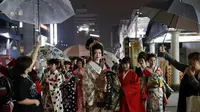 Sejumlah wanita Jepang berjalan di jalan setelah menghadiri peragaan busana kimono di Oita (18/10/2019). Sebutan lain untuk kimono adalah gofuku. Istilah gofuku mulanya dipakai untuk menyebut pakaian orang negara Dong Wu yang tiba di Jepang dari daratan China. (AP Photo/Christophe Ena)