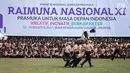 Sejumlah peserta beraksi dalam pembukaan Raimuna Nasional XI di Bumi Perkemahan Cibubur, Jakarta, Senin (14/8). Acara ini diikuti 15.000 Pramuka usia 16-25 tahun dari 34 provinsi dan 514 kota/kabupaten dari seluruh Indonesia. (Liputan6.com/Faizal Fanani)