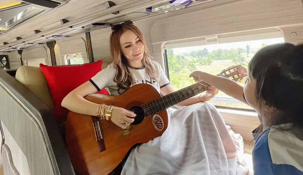 Dalam liburannya kali ini Momo memilih untuk liburan ke Banyuwangi, Jawa Timur. Selama perjalanan, penyanyi ini abadikan momen seru kebersamaannya dengan anak-anak waktu menikmati momen perjalanan sambil bermain gitar. (Liputan6.com/IG/@therealmomogeisha)