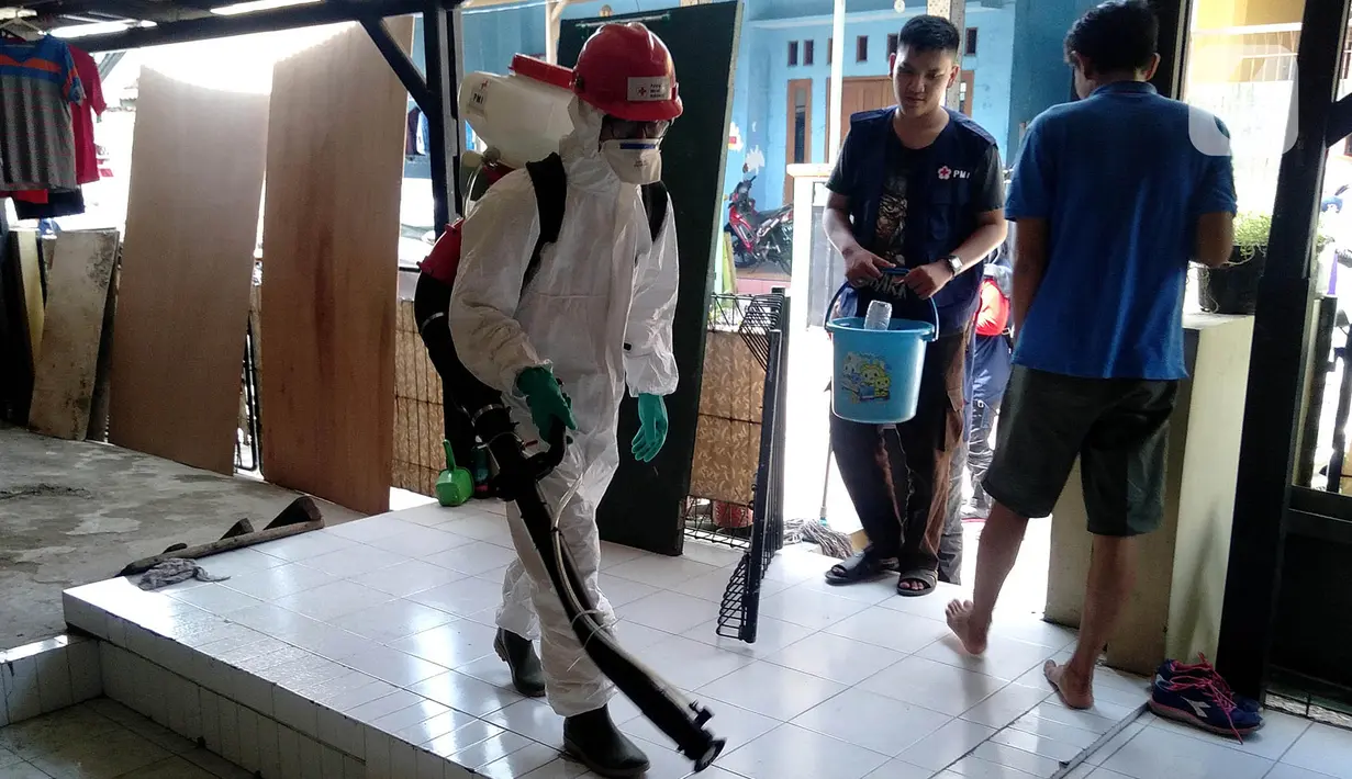 Petugas Palang Merah Indonesia (PMI) Kota Tangerang melakukan penyemprotan Desinfektan di Perumahan Pondok Arum, Karawaci, Tangerang, Rabu (29/1/2020). Penyemprotan dilakukan untuk mencegah bakteri dan  virus yang diakibatkan dari lingkungan yang kotor dari bekas banjir. (merdeka.com/Arie Basuki)