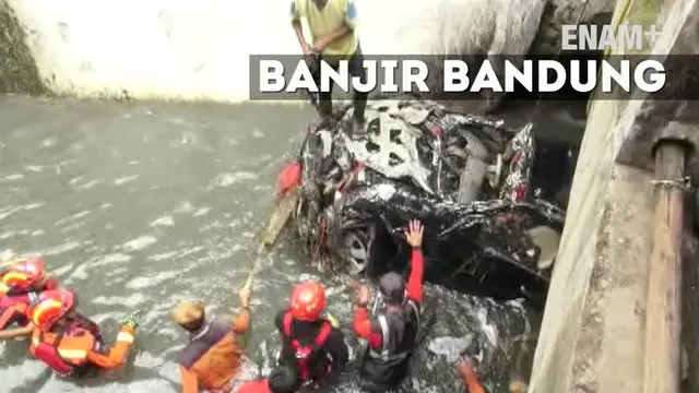 Petugas Damkar Kota Bandung mengevakuasi mobil warga yang terseret banjir hingga 1 Km. Evakuasi dilakukan dengan menggunakan alat berat