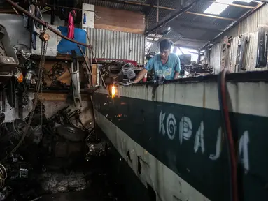 Pekerja membongkar Koperasi Angkutan Jakarta (Kopaja) yang akan diremajakan di kawasan Meruya, Jakarta Barat, Rabu (27/1/2021). Kopaja yang tak lagi digunakan tersebut dihancurkan untuk dijual secara kiloan ke penjual besi tua. (Liputan6.com/Johan Tallo)