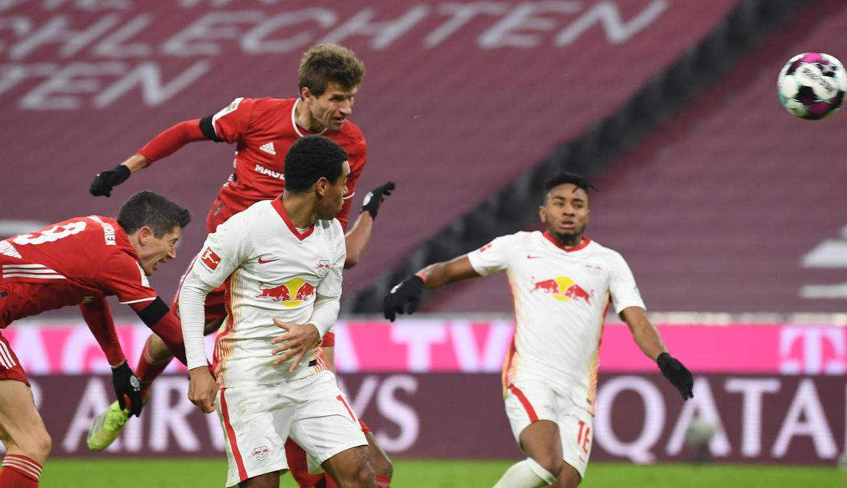 Striker Bayern Munich, Thomas Mueller, mencetak gol penyeimbang 3-3 lewat tandukan kepala dalam laga lanjutan Liga Jerman pekan ke-10 melawan RB Leipzig di Allianz Arena, Sabtu (5/12/2020). Bayern Munich bermain imbang 3-3 dengan RB Leipzig. (AFP/Andreas Gebert/Pool)