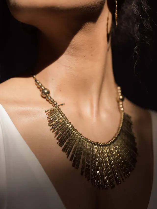 Ilustrasi kalung bib sebagai statement pada outfit.