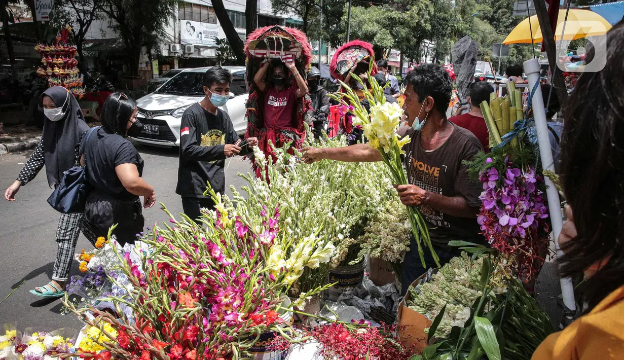 Penjual melayani pembeli bunga hias di Pasar Petak Sembilan, Glodok, Jakarta, Senin (31/1/2022). Jelang tahun baru Imlek 2573 sejumlah bunga seperti sedap malam, aster, mawar dan lainnya mulai banyak dicari warga Tionghoa untuk sembahyang. (Liputan6.com/Faizal Fanani)