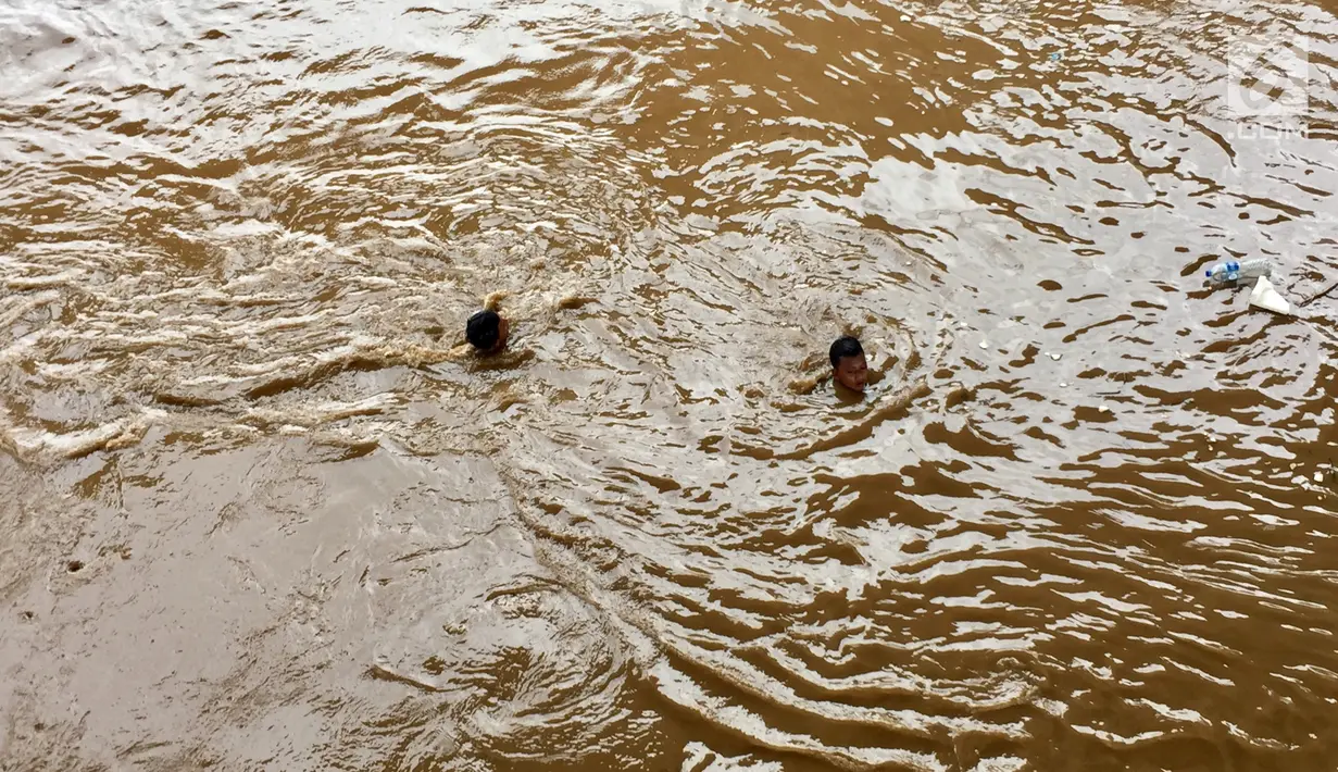 Pemandangan saat anak-anak berenang di derasnya arus Sungai Ciliwung, Rawajati, Jakarta, Selasa (6/2). Anak-anak tidak memperhatikan bahaya yang mengancam nyawa mereka. (Liputan6.com/Immanuel Antonius)