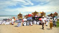 Umat Hindu Bali melakukan upacara Melasti di pantai Petitenget, Bali, Rabu (14/3). Sebelum Hari Raya Nyepi, masyarakat Bali yang beragama Hindu melakukan upacara Melasti ke laut. (AFP Photo/Sonny Tumbelaka)