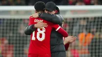 Pelatih Liverpool, Jurgen Klopp memeluk pemainnya, Cody Gakpo dalam perayaan kemenangan 2-1 atas Fulham pada laga leg pertama babak semifinal Carabao Cup 2023/2024 di Anfield Stadium, Liverpool, Kamis (11/1/2024) dini hari WIB. (AP Photo/Jon Super)