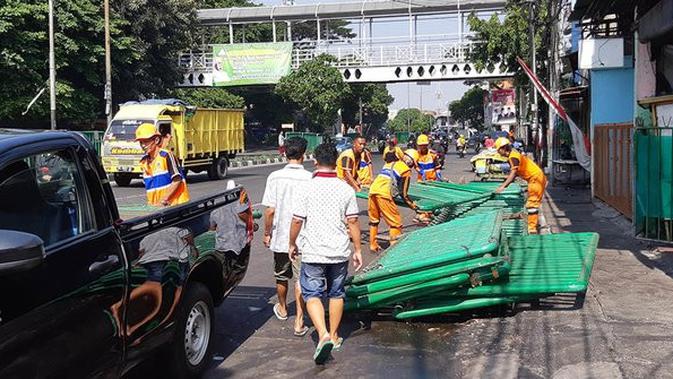 Petugas Penanganan Prasarana dan Sarana Umum (PPSU) atau Pasukan Oranye membersihkan sisa puing-puing pasca kerusuhan di MH. Thamrin. (Liputan6.com/Fachrur Rozie)