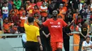 Pemain depan Persija Jakarta, Edi Foday Boakay (kanan), mendapat kartu kuning dari wasit Handri Kristanto saat berlaga di Stadion GBK, (10/8/2014). (Liputan6.com/Helmi Fithriansyah)  