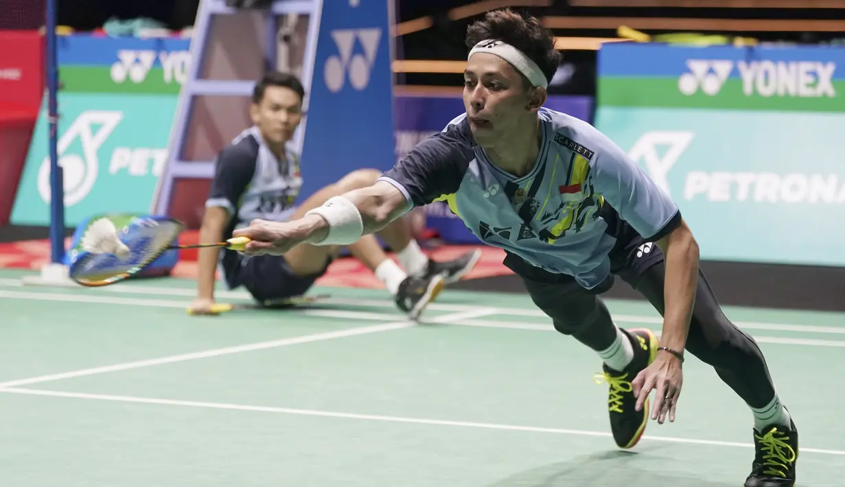 Pebulu tangkis ganda putra Indonesia, Muhammad Rian Ardianto (kanan) berusaha membalikkan shuttlekok dari pasangan China dalam babak final Malaysia Open 2023 di Axiata Arena, Kuala Lumpur, Minggu (15/1/2023). Fajar/Rian pun berhasil menang dan meraih titel juara Malaysia Open 2023 dengan kemenangan 21-18, 18-21, 21-13. (AP Photo/Kien Huo)