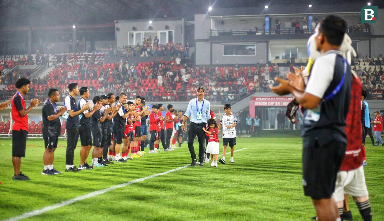 Suporter membentangkan spanduk bertuliskan "Obrigado Teco, You Made Us Dream" dengan menyalakan flare di Stadion Kapten I Wayan Dipta usai pertandingan menghadapi Madura United. (Bola.com/Alit Binawan)