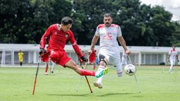 Pemain Timnas Amputasi Indonesia, Agung Rizki Satria (kiri) berusaha mengumpan bola dibayangi pemain Iran dalam laga Grup A Kualifikasi Piala Dunia Amputasi 2026 di Stadion Madya, Senayan, Jakarta, Kamis (13/11/2025). (Bola.com/Bagaskara Lazuardi)