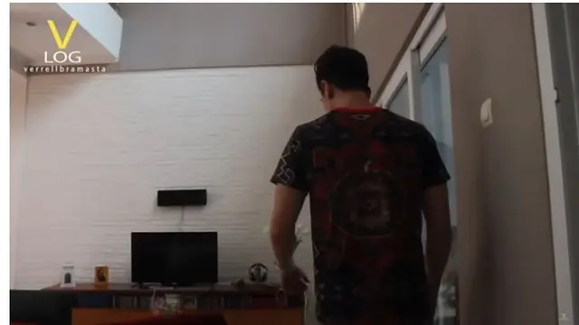 Ruang tamu di rumah seleb bersaudara ini ada televisinya. Dindingnya tersusun bata warna putih.