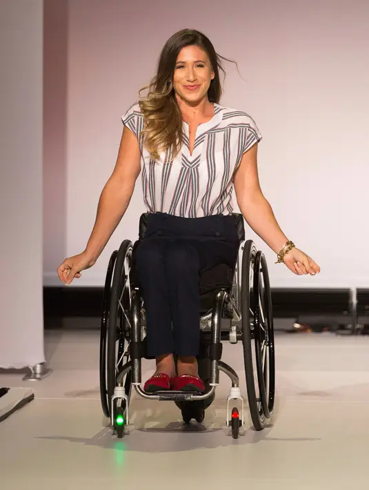 Model difabel dengan kursi berjalan di atas catwalk mengenakan koleksi The Runway of Dreams selama peragaan busana di New York, Rabu (5/8). Pagelaran itu menampilkan kaum difabel menggunakan pakaian yang disesuaikan dengan kondisi mereka. (AP/Kevin Hagen)