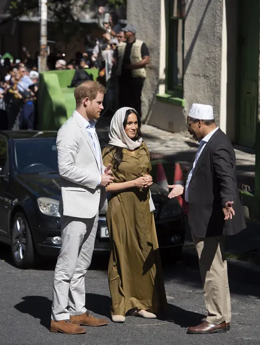 Duchess of Sussex Meghan Markle bersama suaminya, Pangeran Harry berbincang dengan seorang pria saat mengunjungi Masjid Auwal, Cape Town, Afrika Selatan (24/9/2019). (AFP Photo/David Harrison)