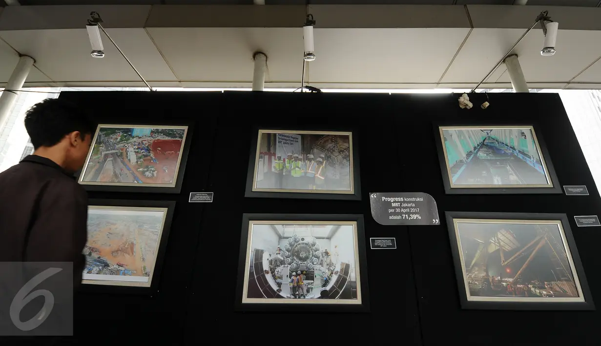 Warga melihat pameran foto kemajuan pembangunan MRT di Jembatan Penyebrangan Orang Bundaran Hotel Indonesia, Jakarta, Minggu (7/5). Pameran bertema Aku, Kamu, Kita #UbahJakarta. (Liputan6.com/Helmi Fithriansyah)