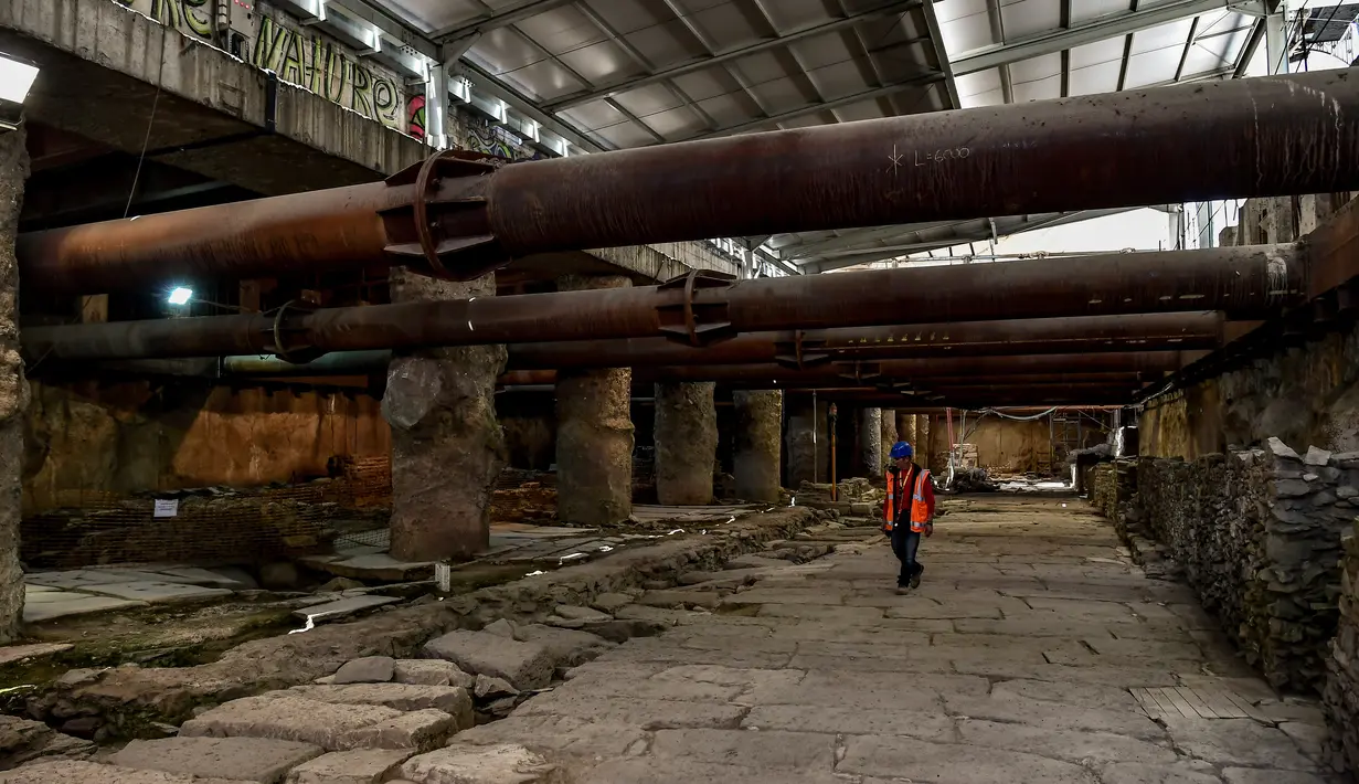 Seorang pekerja berjalan di atas sisa-sisa persimpangan jalan Decumanus Maximus, di sebuah situs kuno di bawah jalan pusat kota Thessaloniki, Yunani (25/4). (AFP/Aris Messinis)